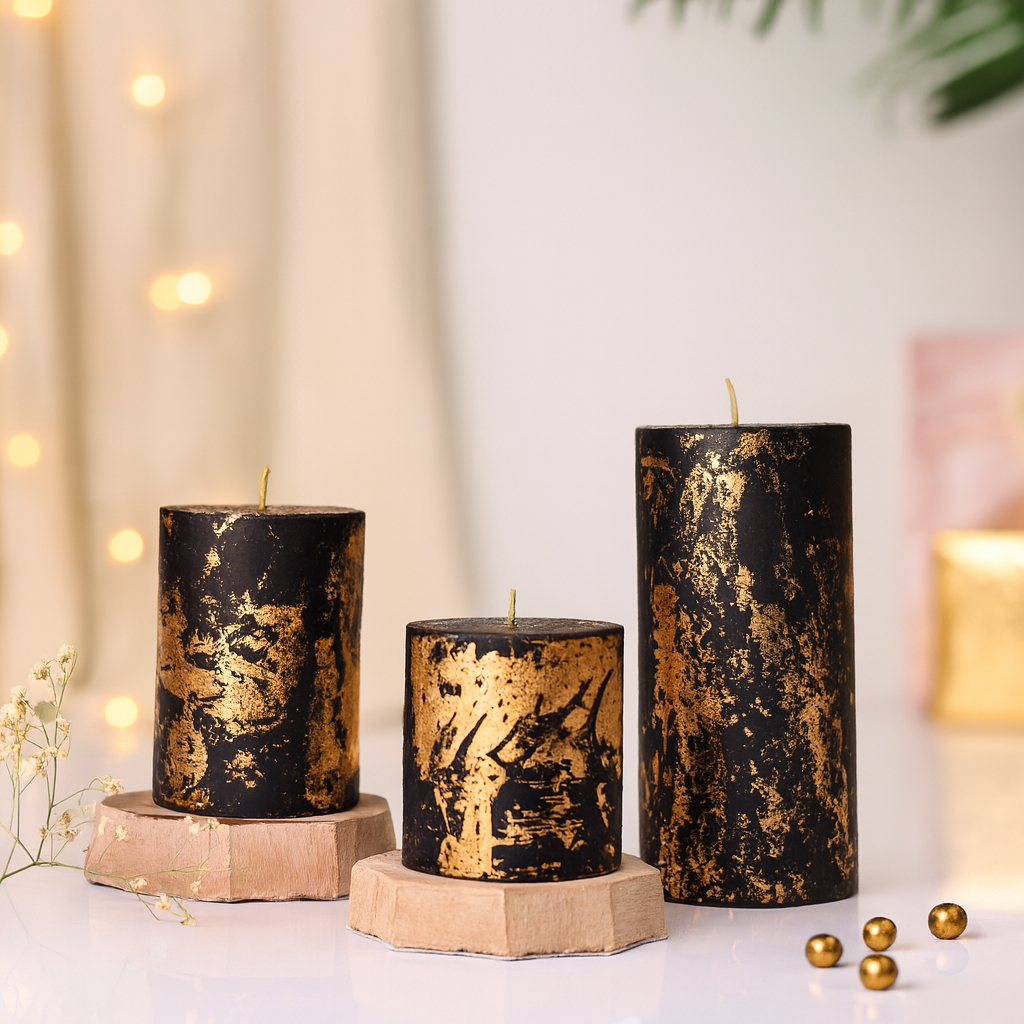 Three black and gold candles on hexagonal stands with a soft, blurred background.