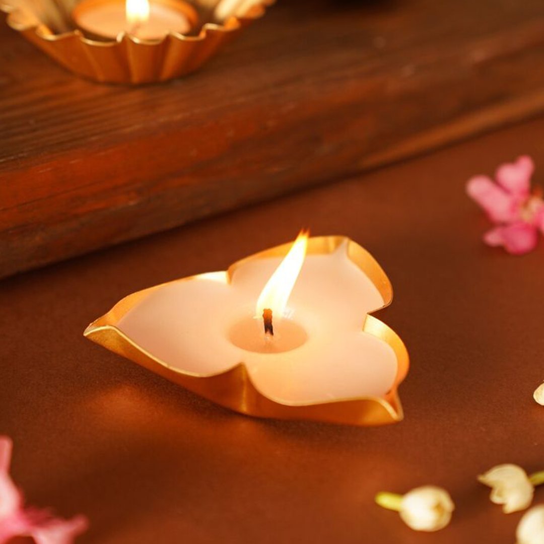 Heart-shaped candle on a wooden surface with flowers around