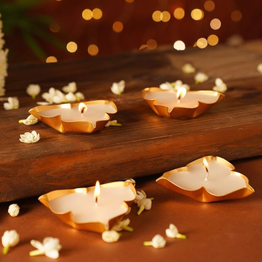Decorative leaf-shaped candles on a wooden surface with a warm, blurred background.