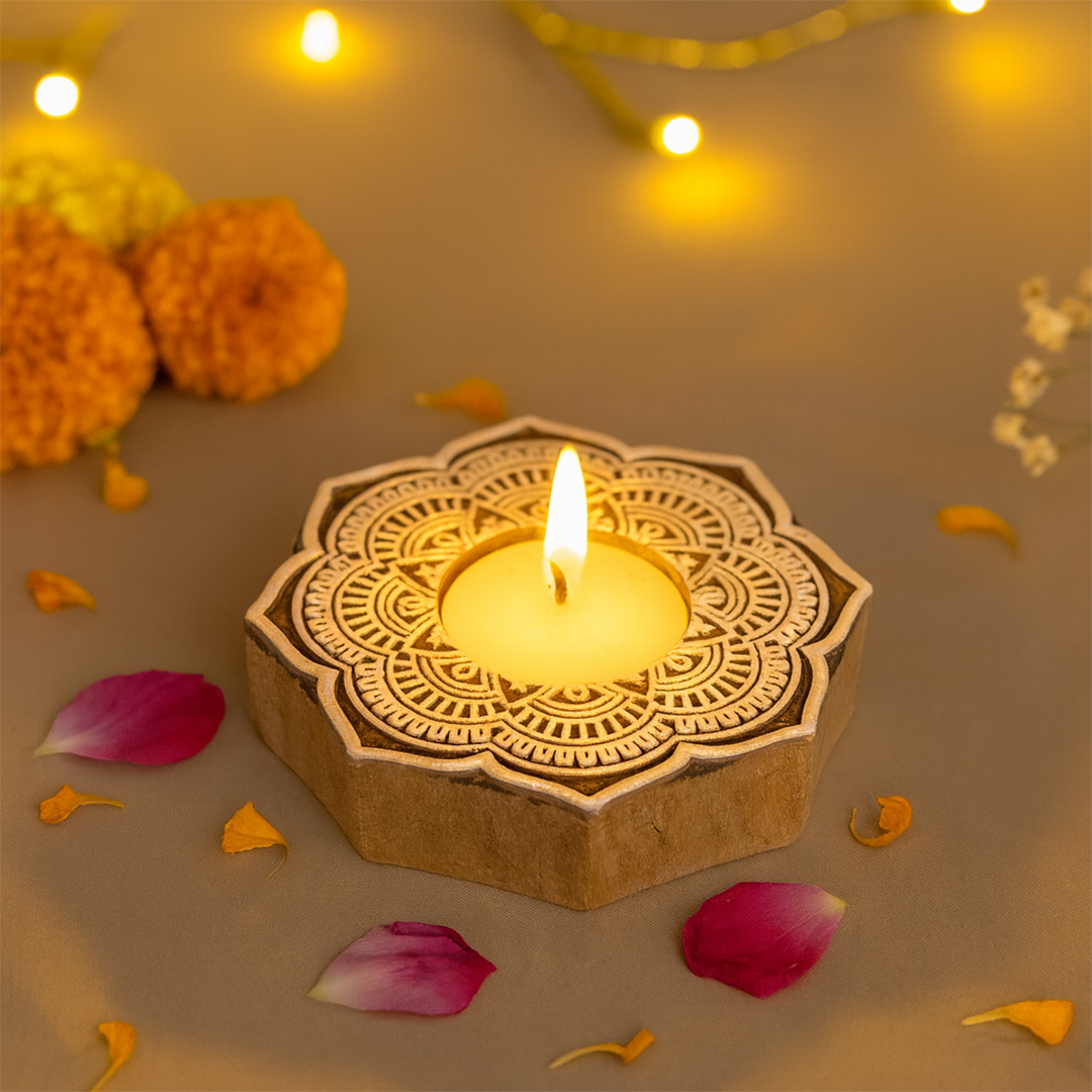 Decorative wooden candle holder with a lit candle surrounded by flowers and petals on a warm-toned background.